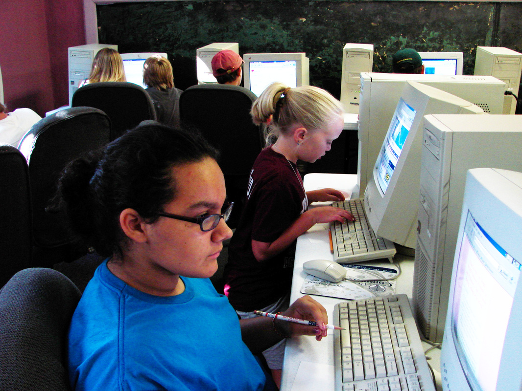 Young people using desktop computers in a classroom.