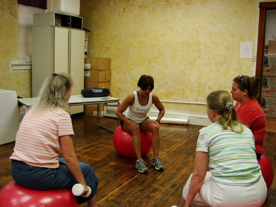 Four participants seated on exercise balls in a room.
